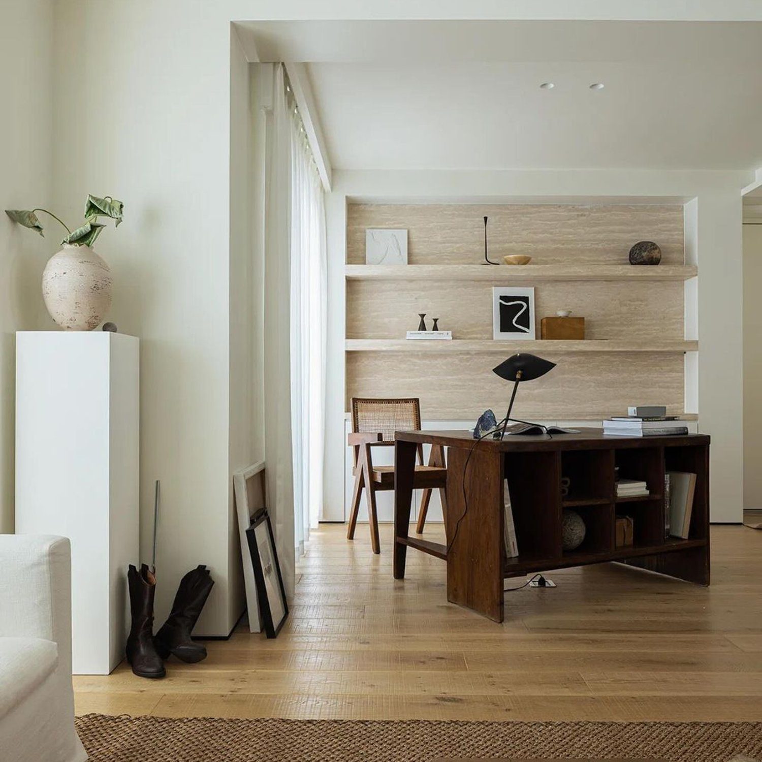 Elegant minimalist home office design with a natural wood desk and shelving, complemented by a textured jute rug and simplistic decor