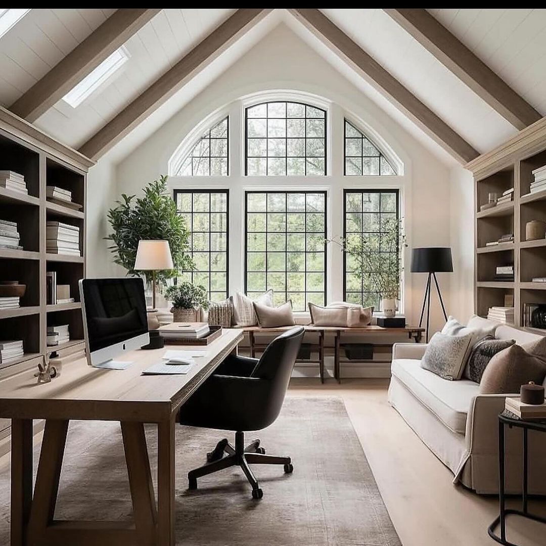 A spacious and modern home office with large arched windows