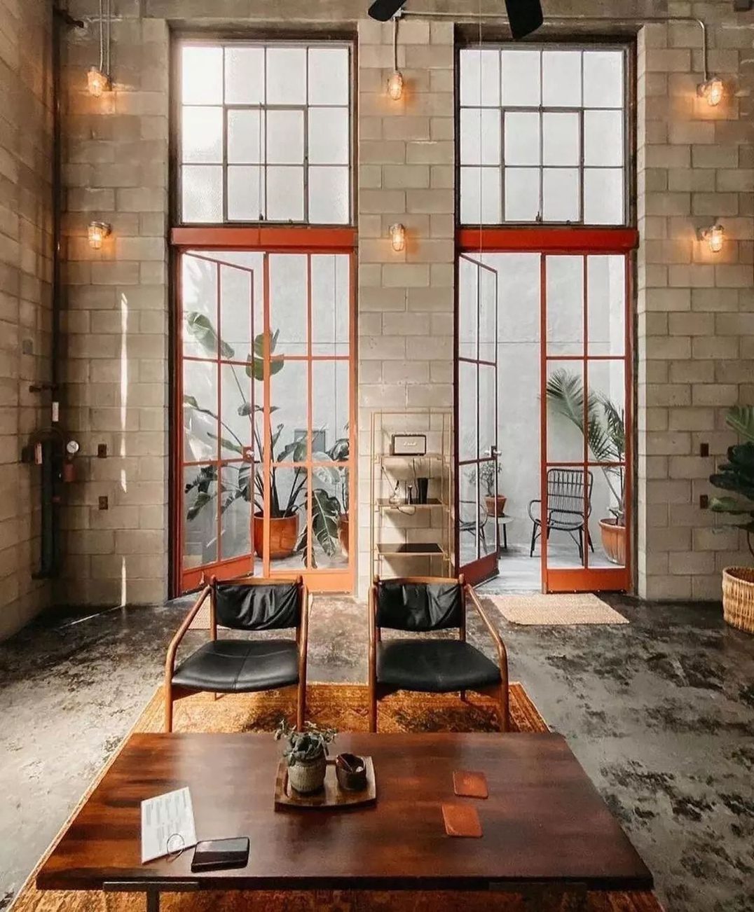 Industrial-style lounge with brick walls and red-framed windows