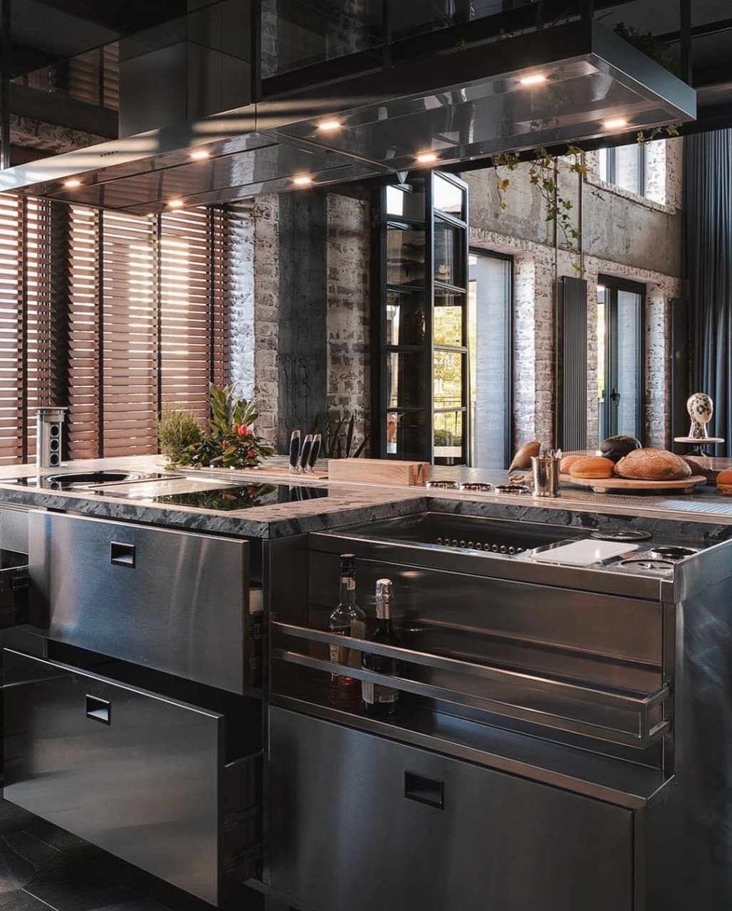 A modern industrial kitchen with sleek stainless steel appliances and exposed brick walls