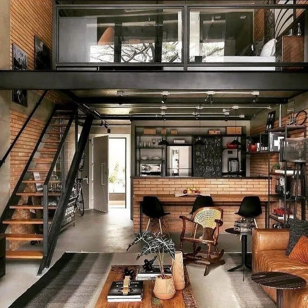 Loft style interior with an industrial touch featuring a combination of exposed brick, dark metal staircases and a mezzanine level