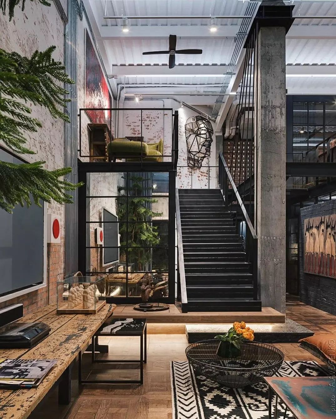 A chic and industrial loft space featuring a black metal staircase