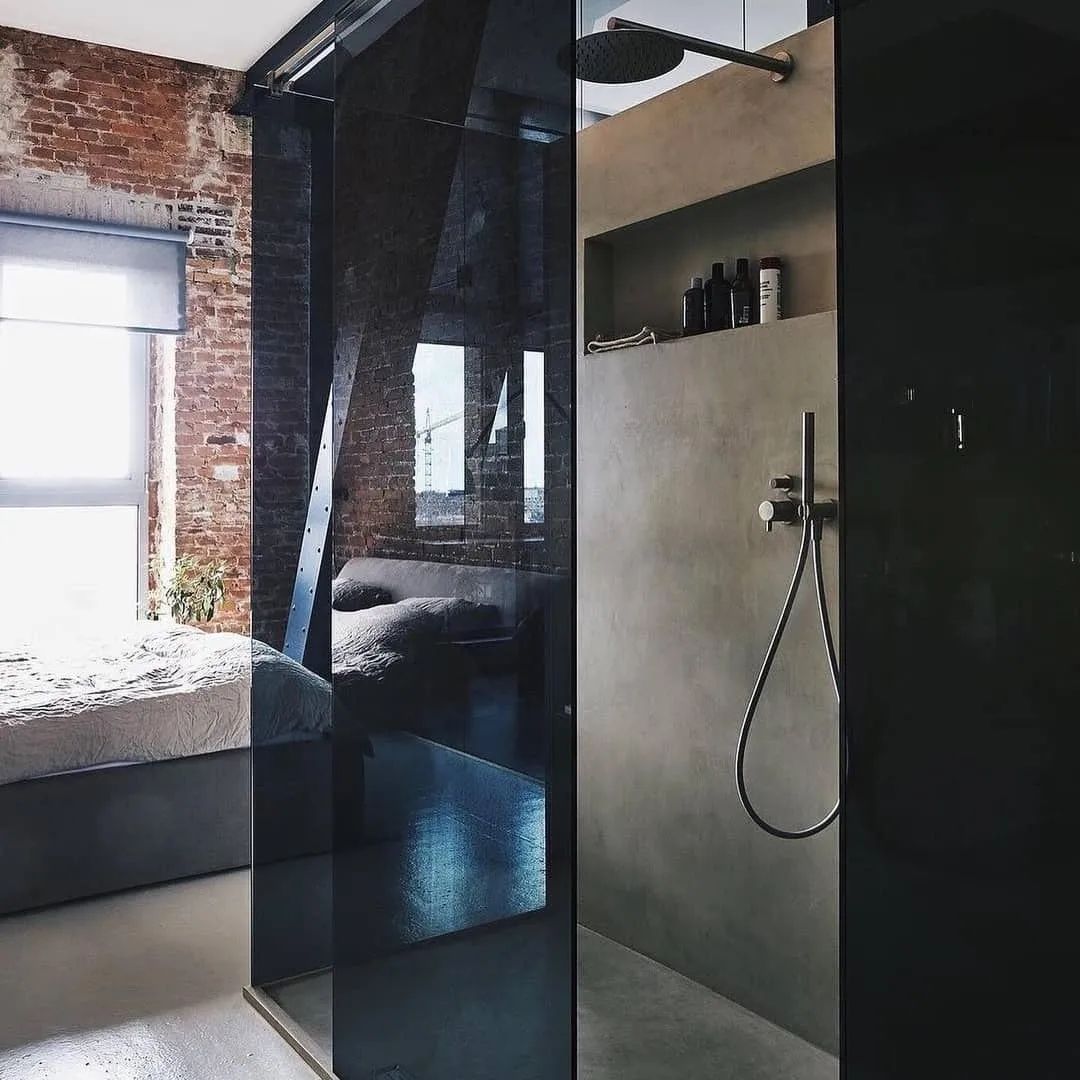 Loft-style bathroom with exposed brick and modern glass shower