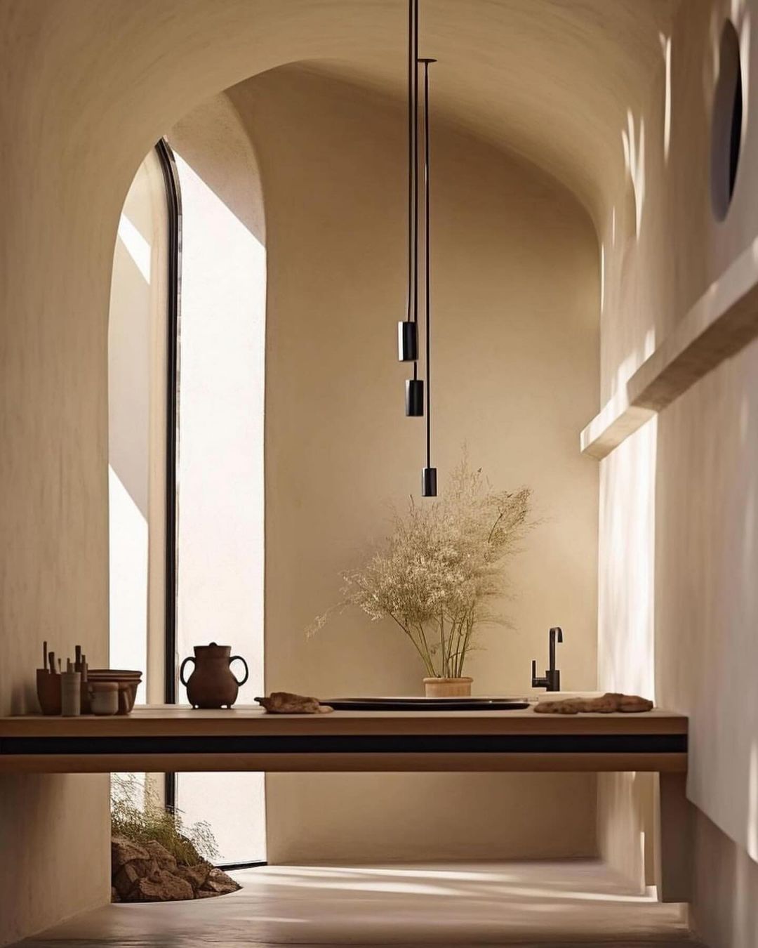 A minimalist interior design of a wash area with arches and warm earth tones