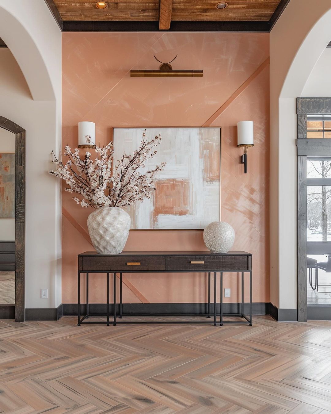 A tastefully designed hallway boasting a herringbone-patterned wooden floor, a sleek console table accentuated with brushed brass hardware, and a statement-making contemporary painting adding a subtle pop of color.