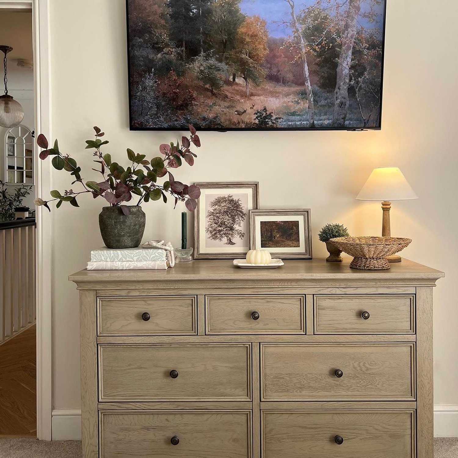 A tastefully decorated room with a rustic wooden dresser