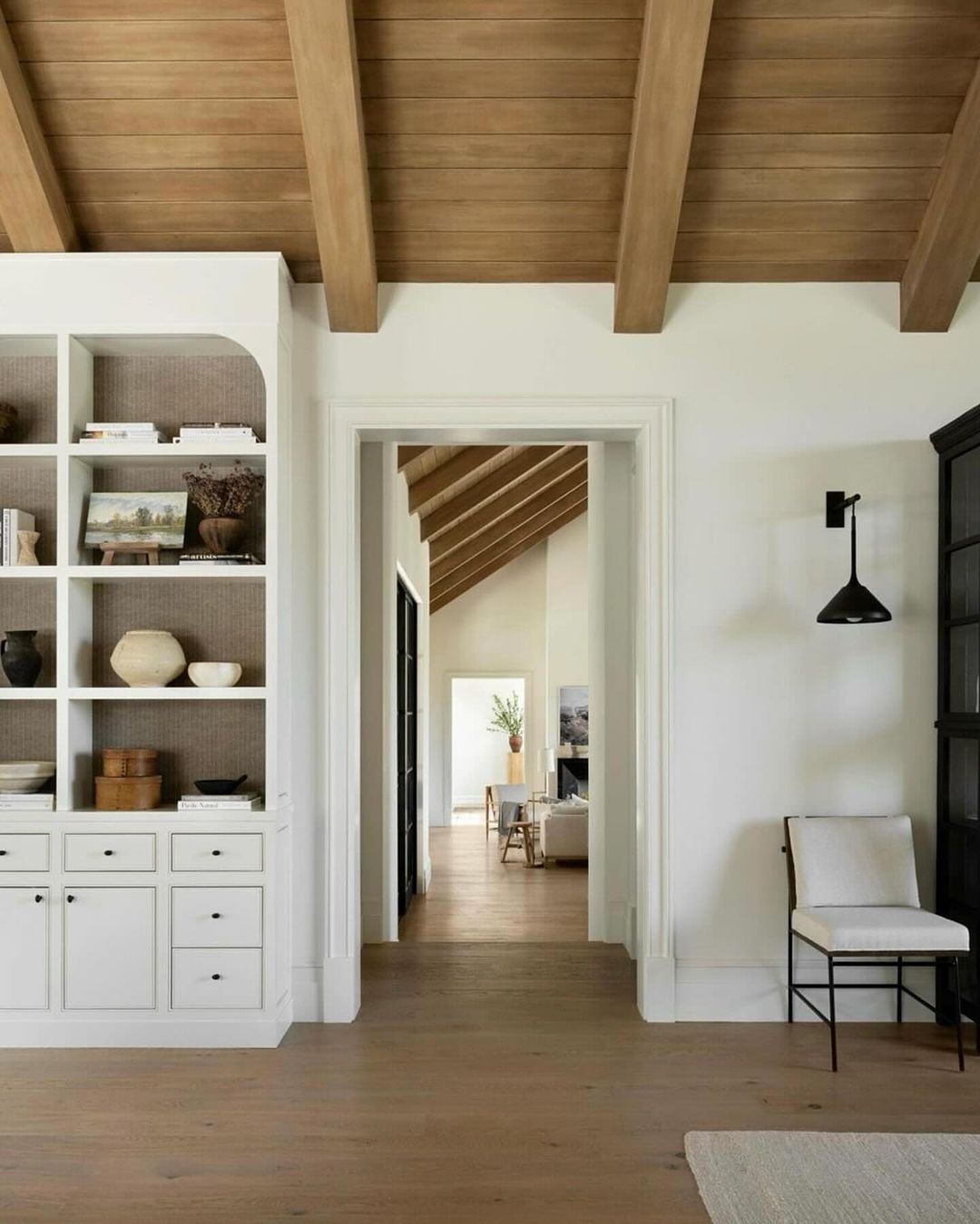 A harmoniously designed modern living space featuring warm wooden ceiling beams