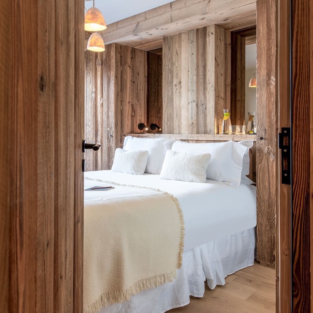 Cozy wooden bedroom with plush white bedding