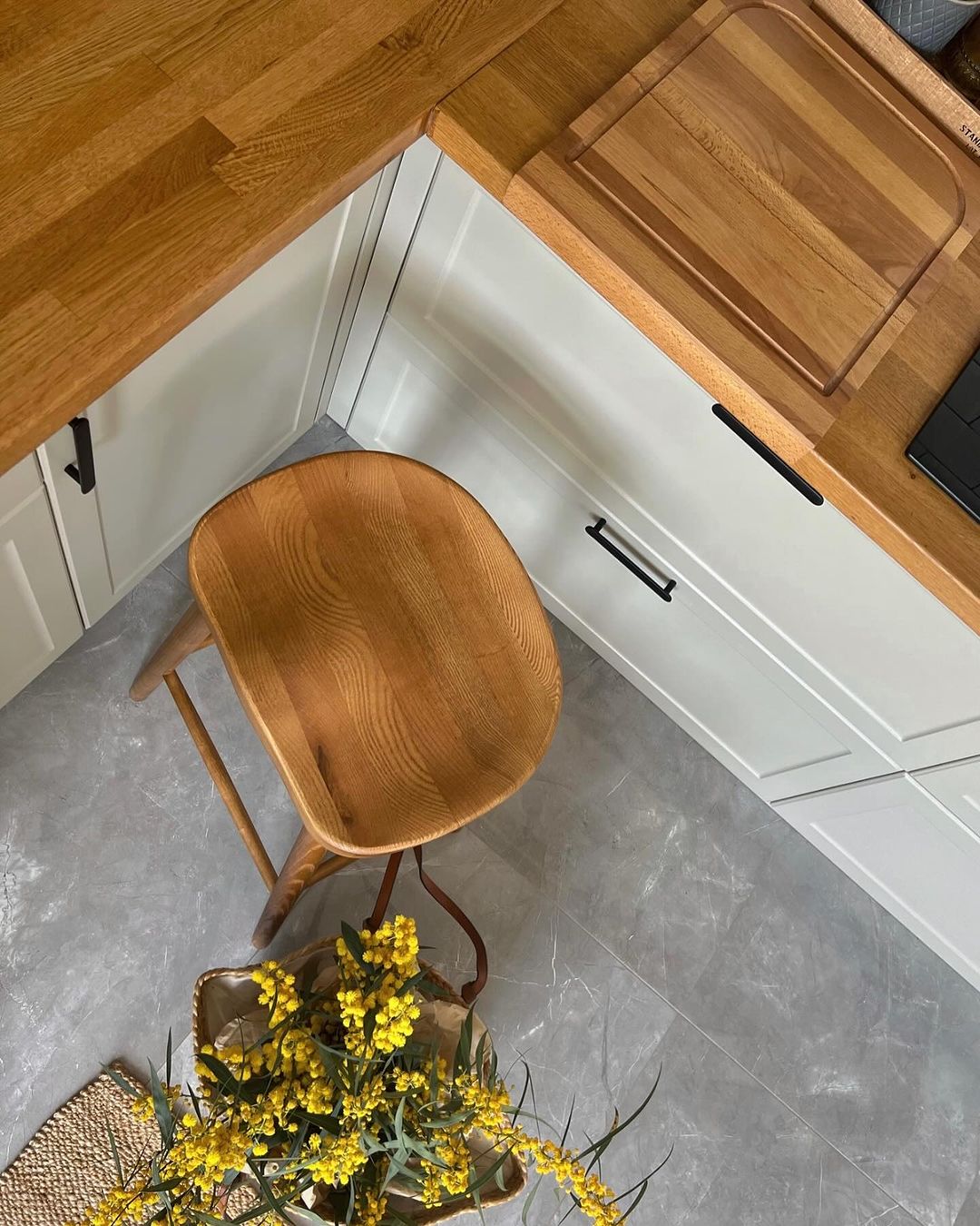 A modern kitchen corner featuring wooden textures and contrasting grey tones