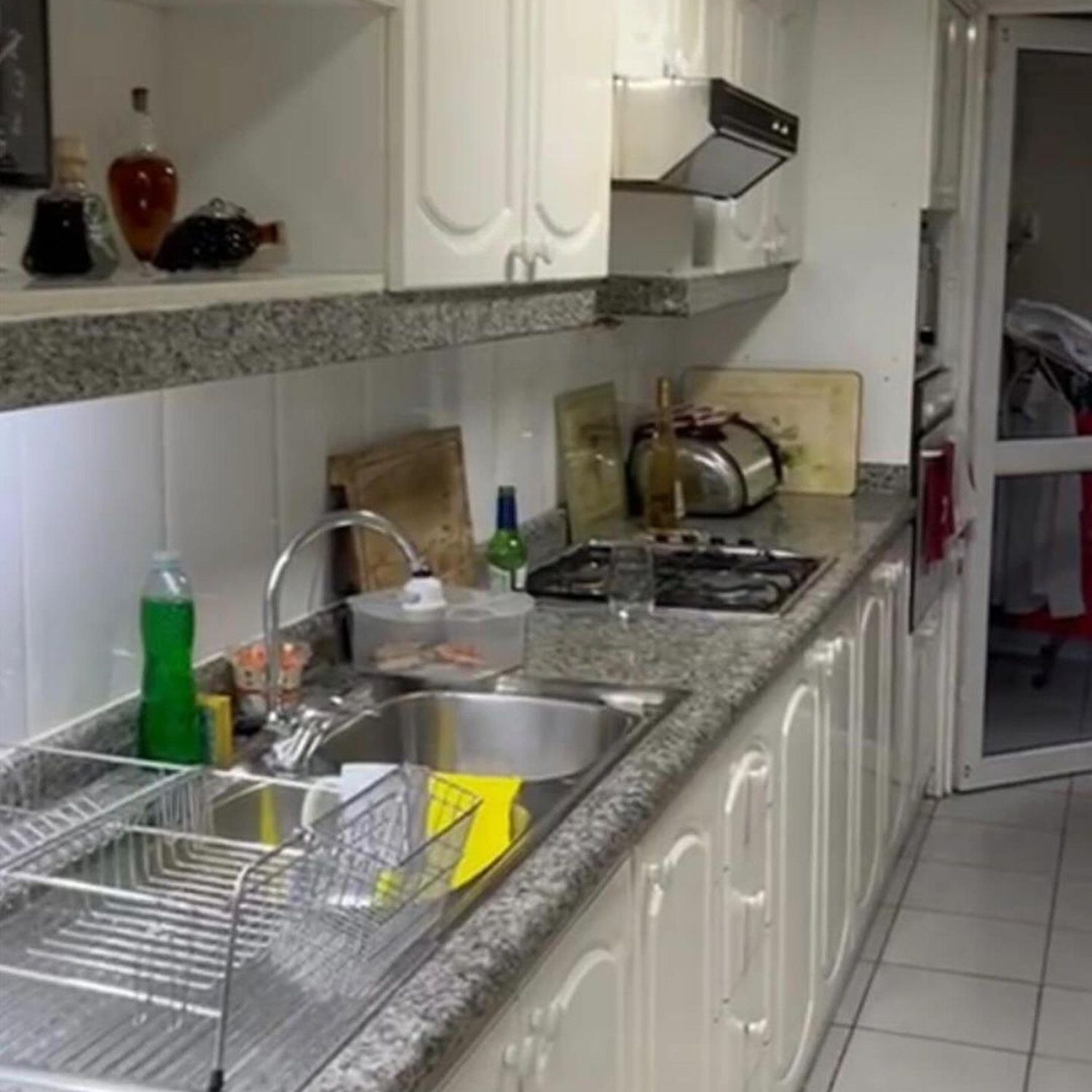 A neatly organized kitchen with white cabinetry and granite countertops