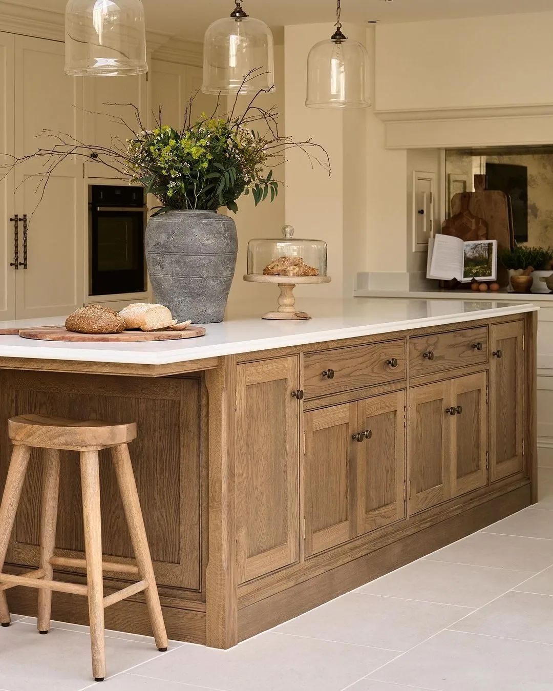 A tastefully designed kitchen featuring oak cabinetry, a large island with seating, and pendant lighting