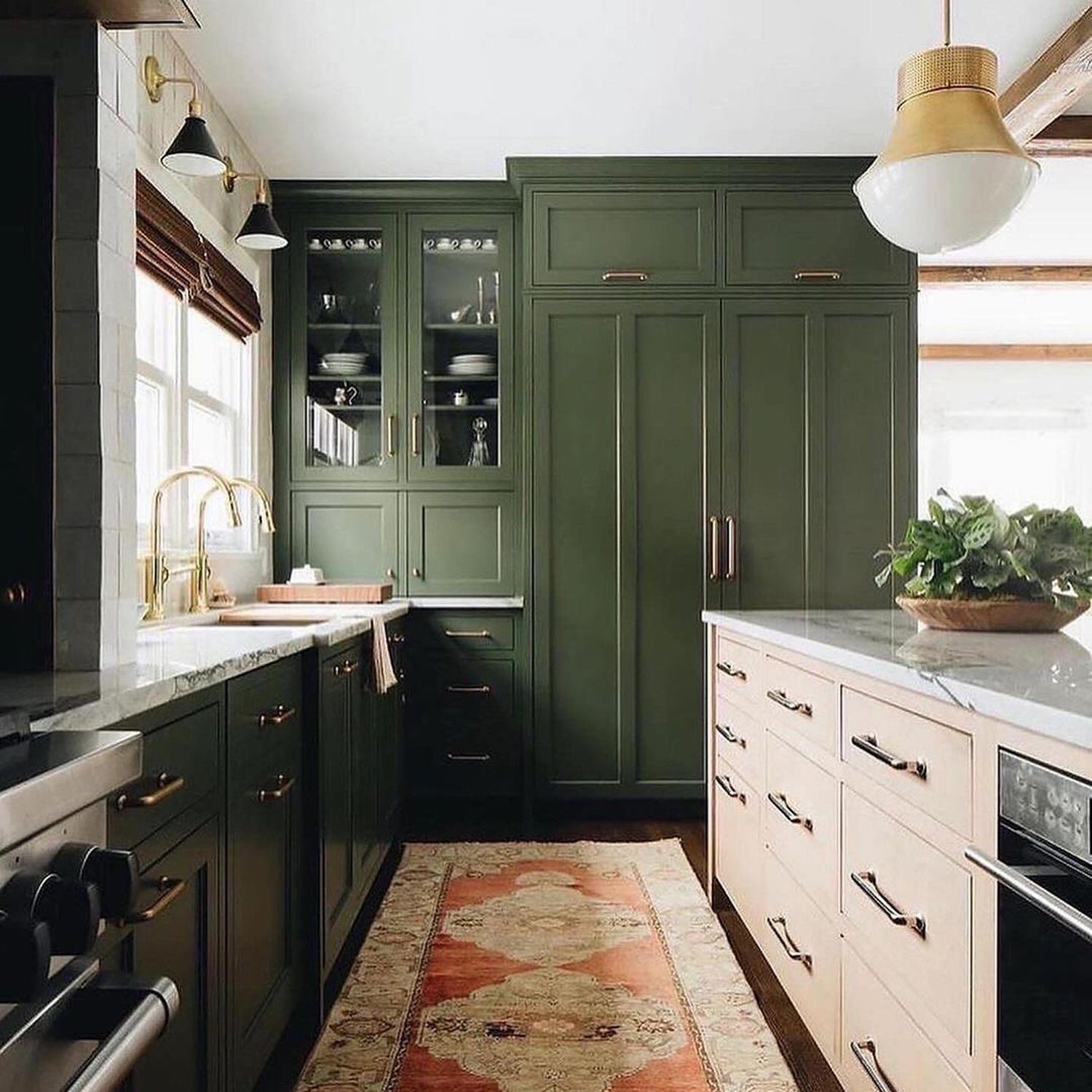 Elegant kitchen with green cabinetry and brass finishes