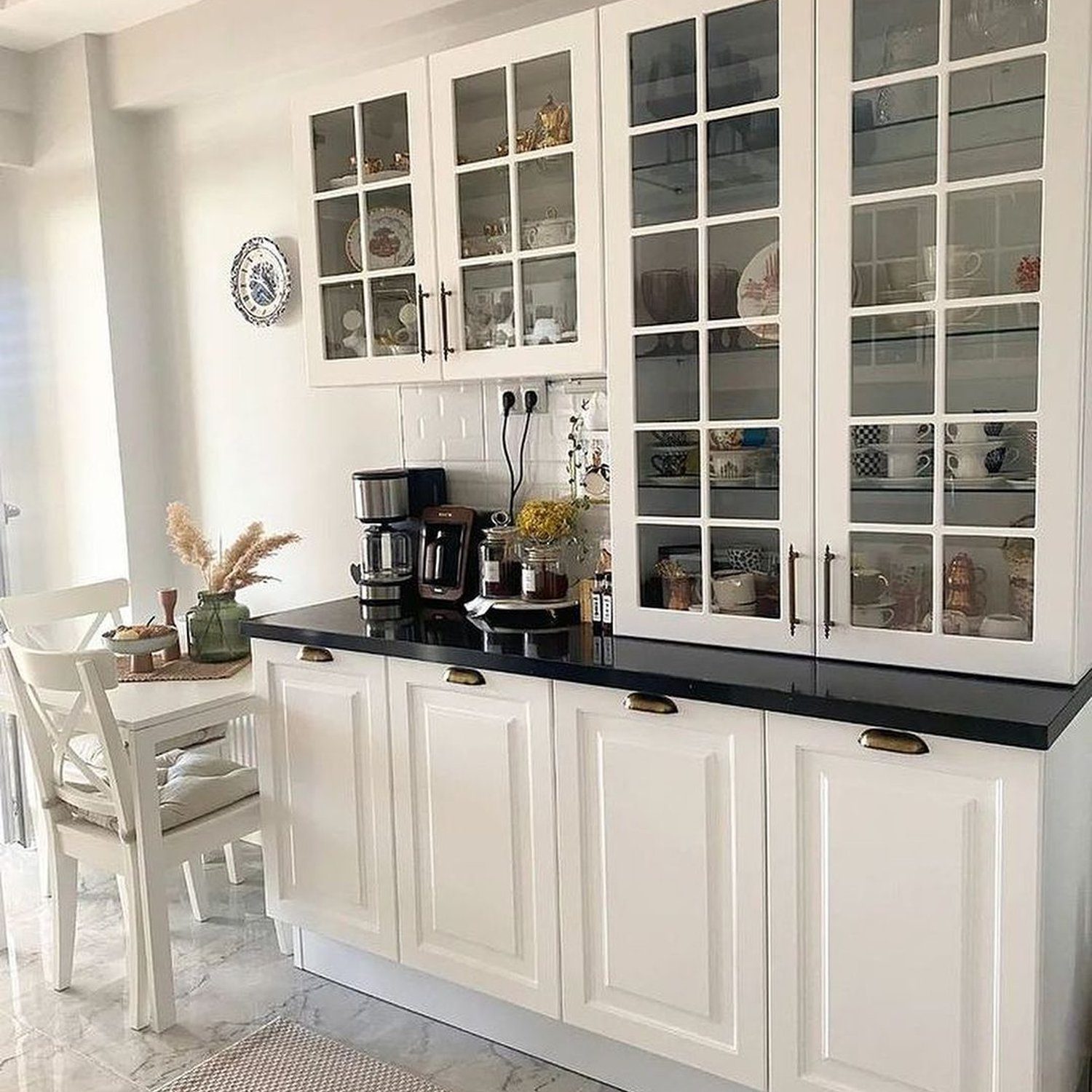 Elegant white kitchen featuring glass-front cabinets filled with fine china