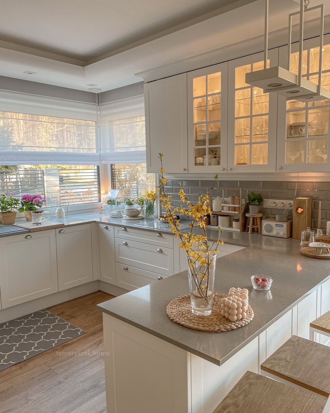 A cozy and well-lit kitchen featuring white cabinetry and modern appliances