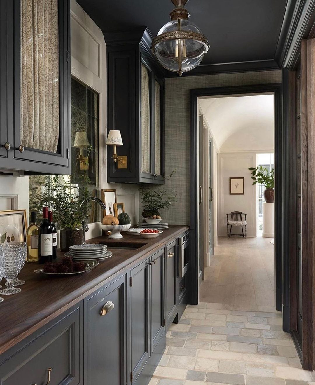 A sophisticated and welcoming kitchen featuring dark wood cabinets and stone tile flooring