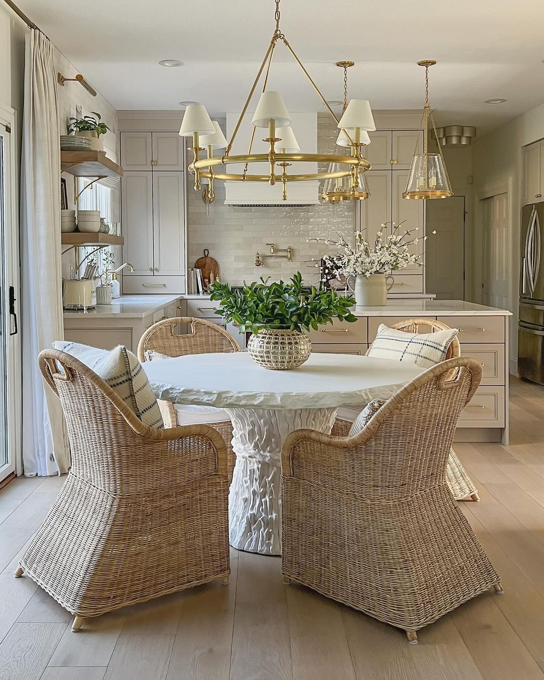 A tastefully designed kitchen nook featuring wicker chairs and a unique white pedestal table