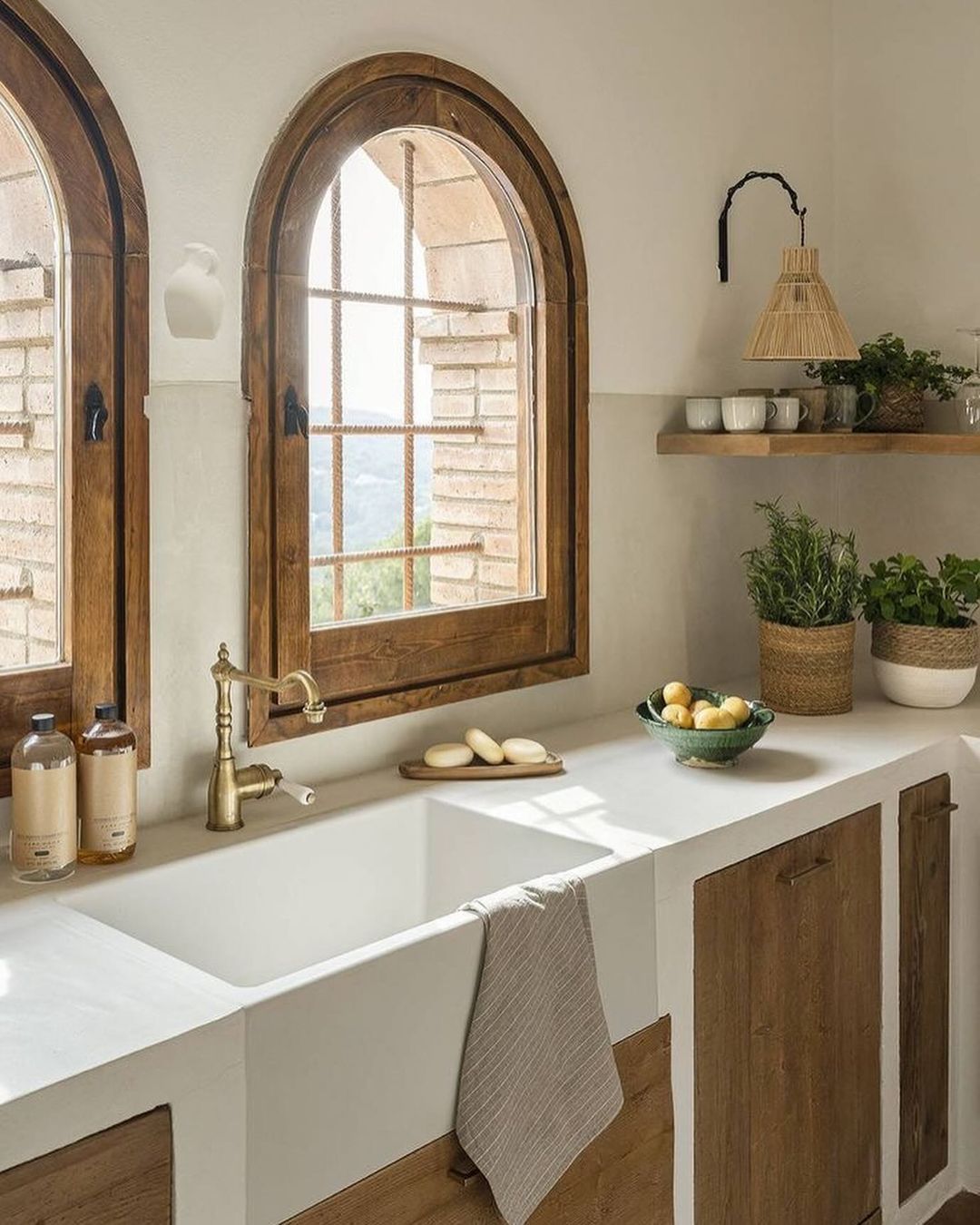 A warm and inviting kitchen space featuring arched windows with a countryside view