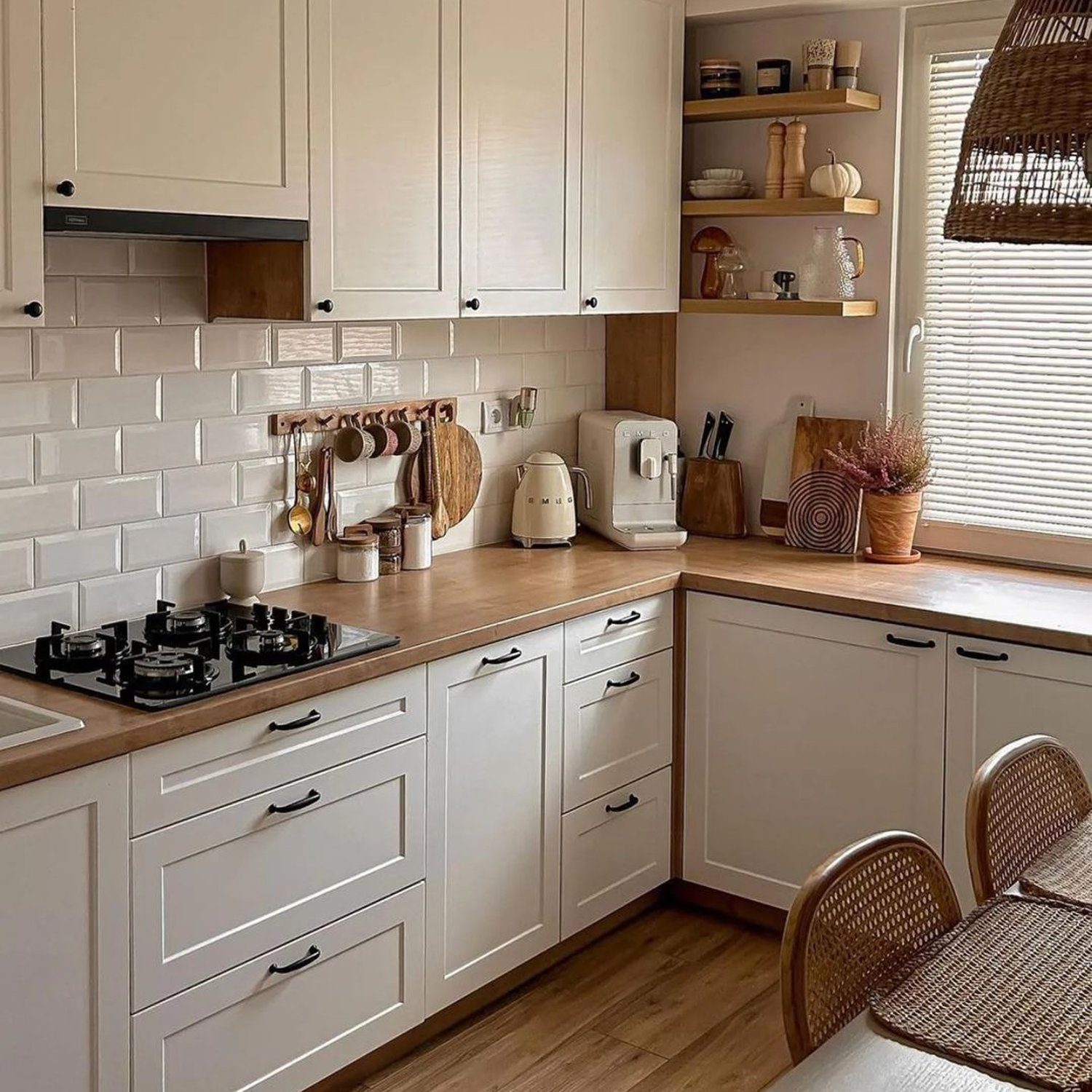 A cozy and stylish kitchen with cream cabinets, natural wood countertops, and white subway tiles.