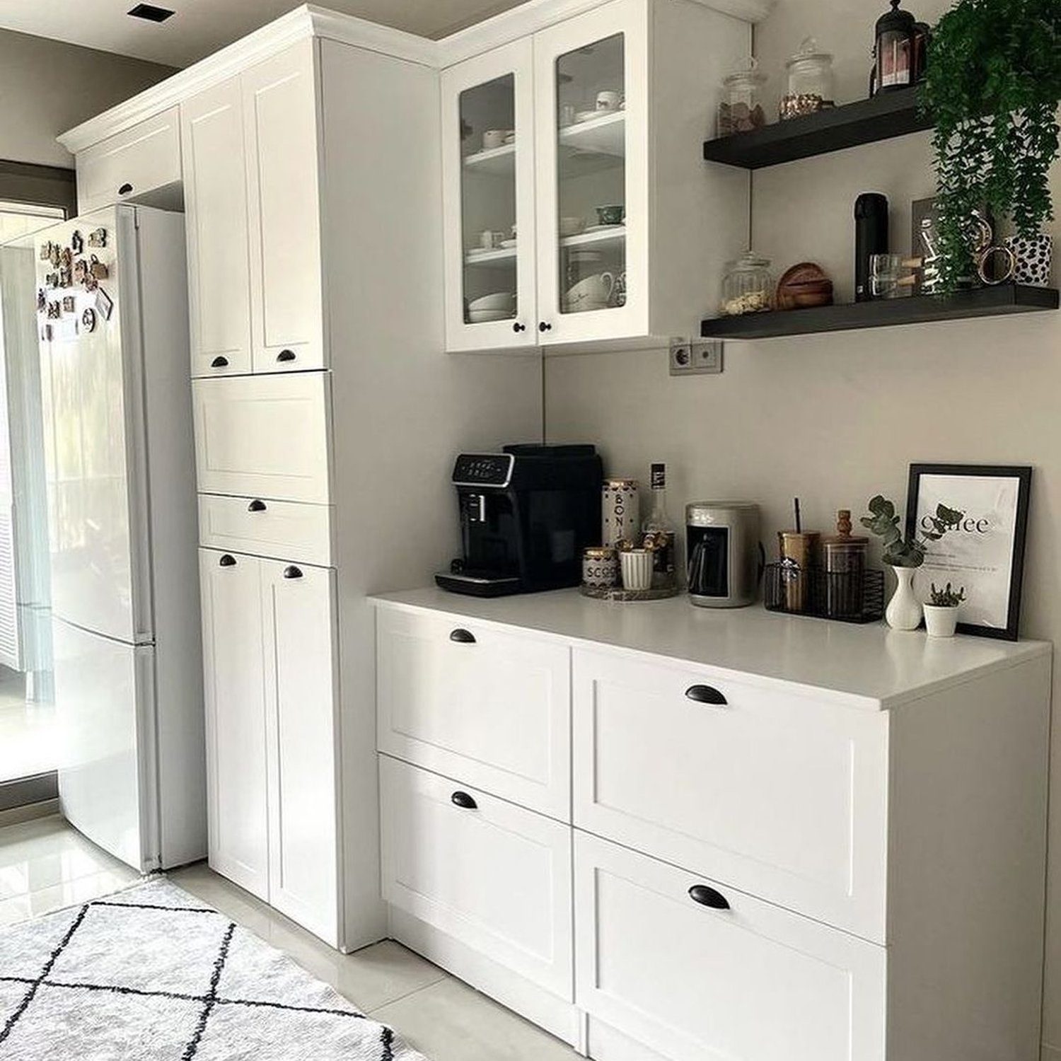 A sleek, modern kitchenette featuring pristine white cabinetry and countertops