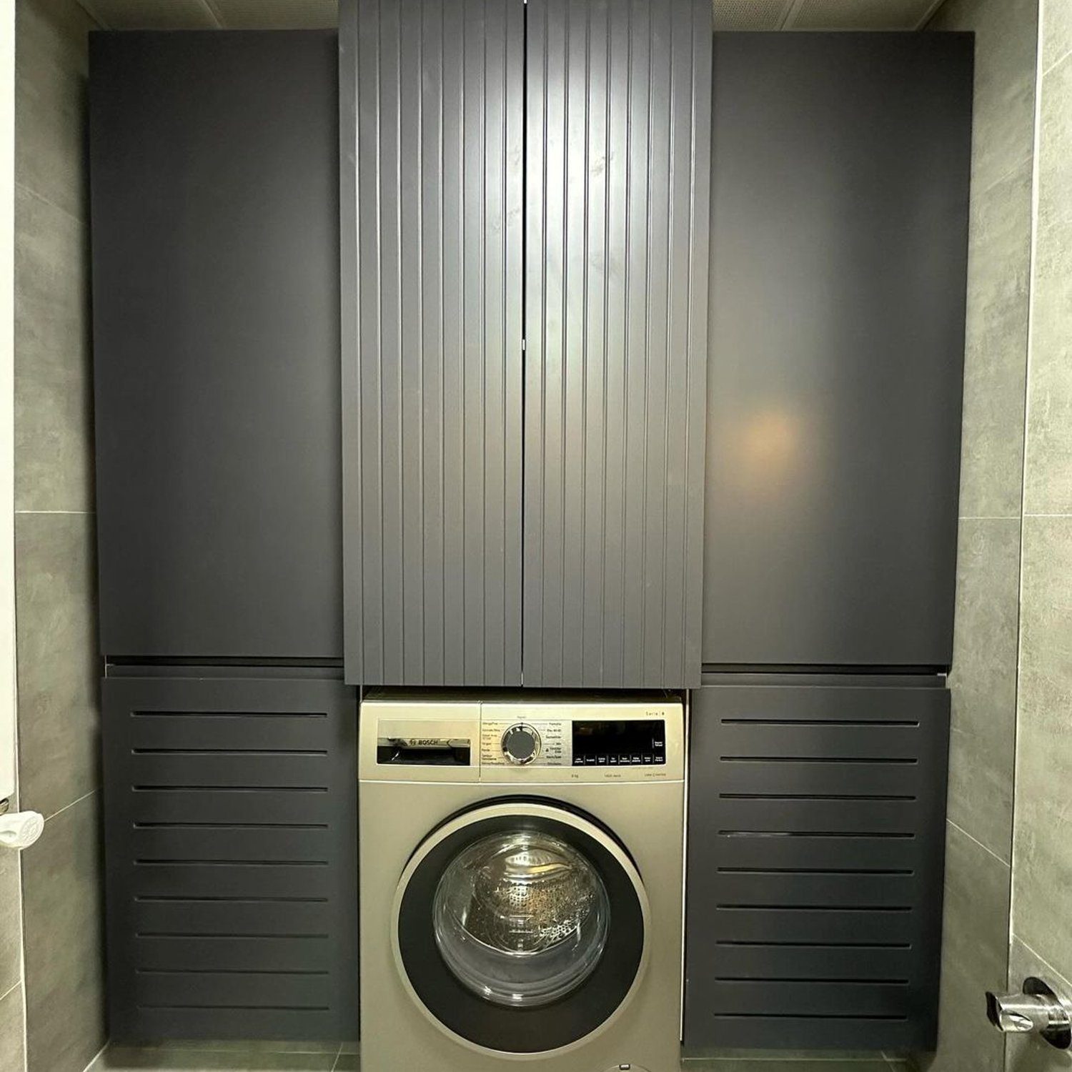 A modern and sleek laundry room set up with a washing machine