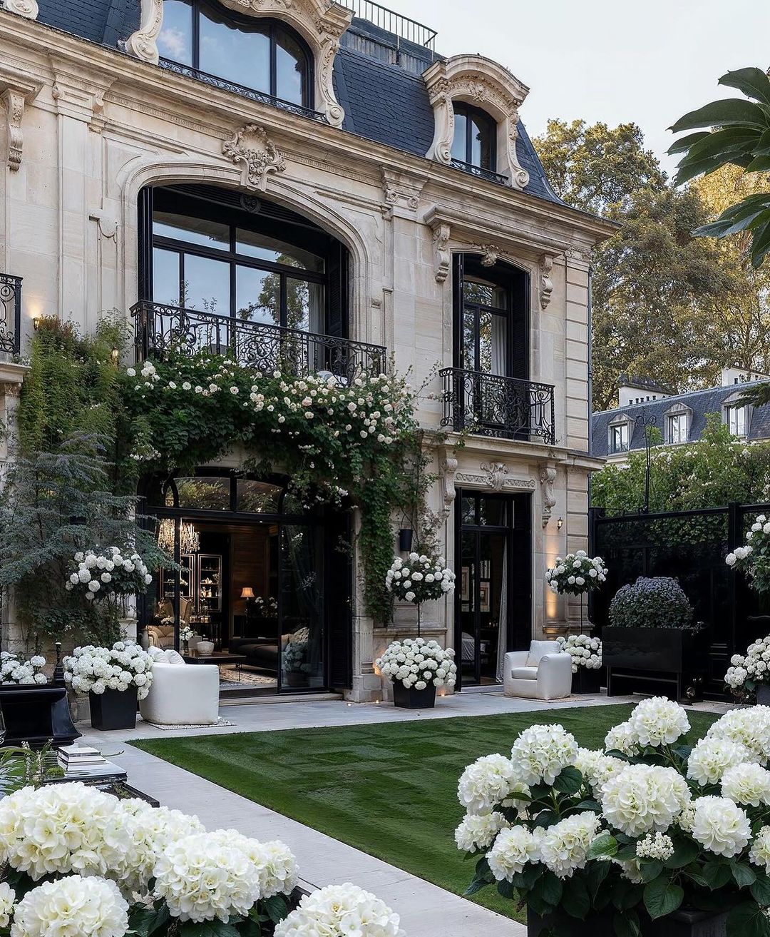 A luxurious Parisian mansion façade adorned with verdant climbers and sumptuous hydrangea arrangements