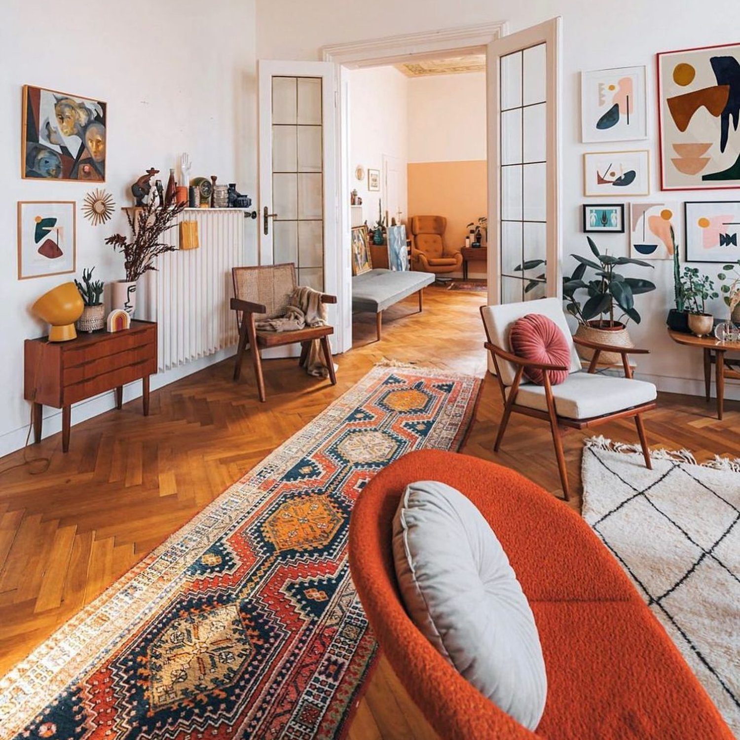 A vibrant and eclectic living room with a mix of mid-century modern furniture and colorful textiles.