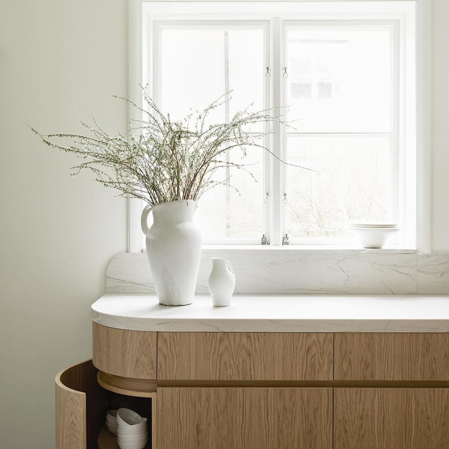 A minimalist kitchen corner showcasing a wooden curved island