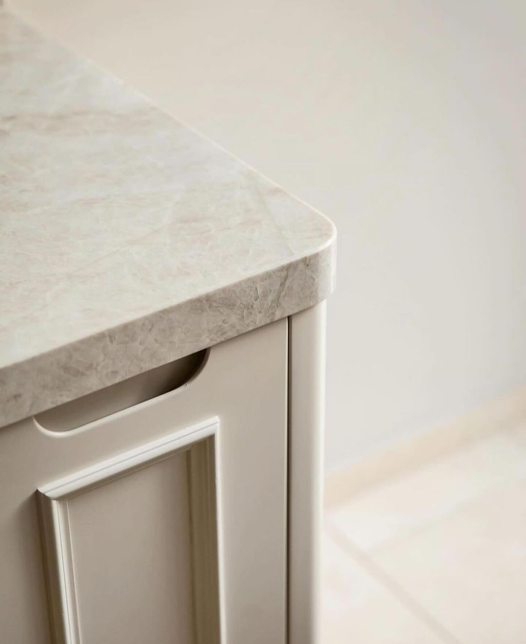 A minimalist kitchen design featuring a marble countertop with sleek cabinetry