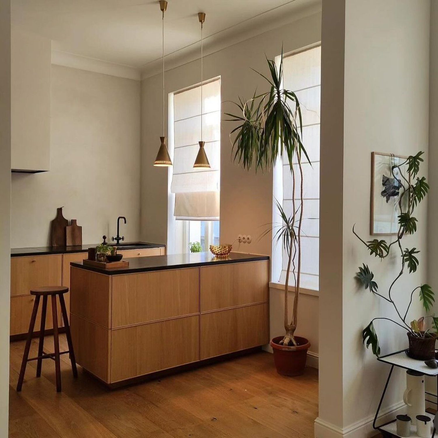 A minimalist kitchen design featuring wooden cabinetry and modern lighting