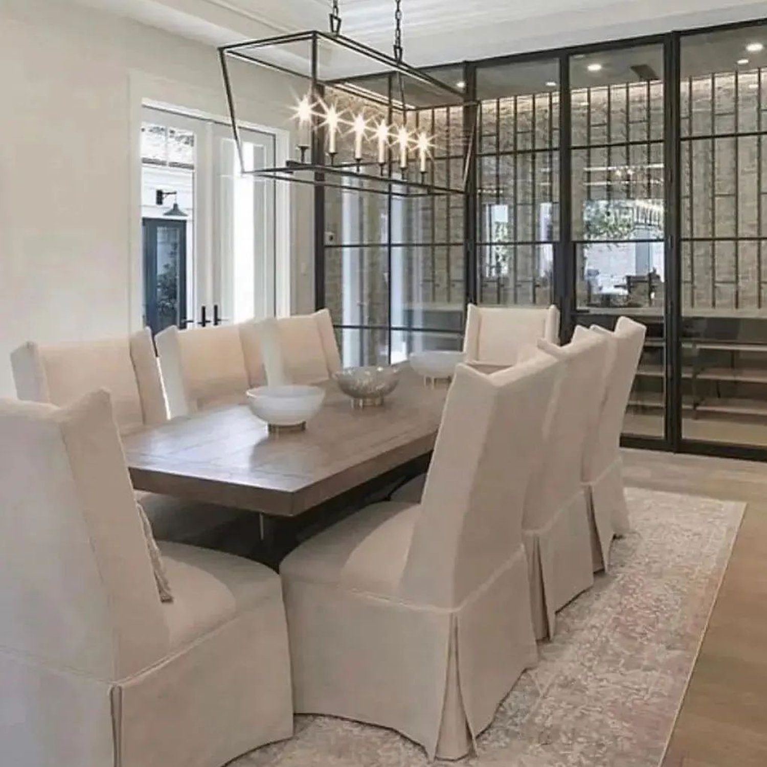 Elegant Dining Area with Paneled Glass Walls and a Rectangular Chandelier