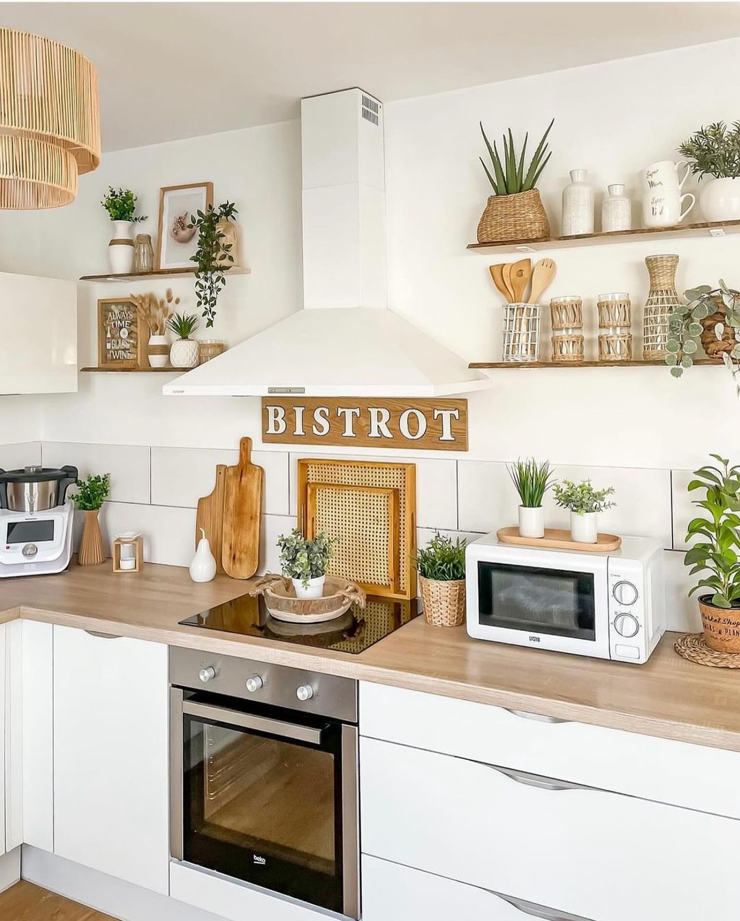 A modern and stylish kitchen featuring white cabinetry, wooden countertops, and a prominent 'BISTROT' sign