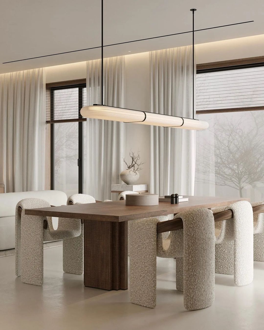 A modern and minimalist dining room featuring textured fabric chairs and a solid wood table