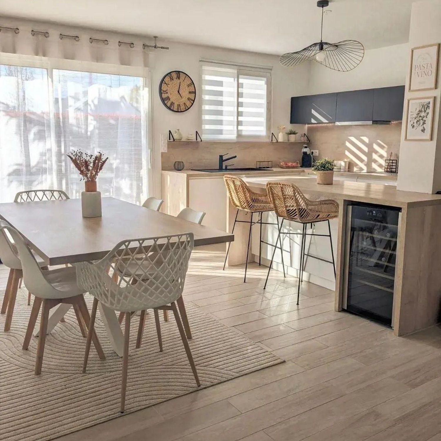 A contemporary kitchen and dining area, featuring a blend of natural light and modern design.