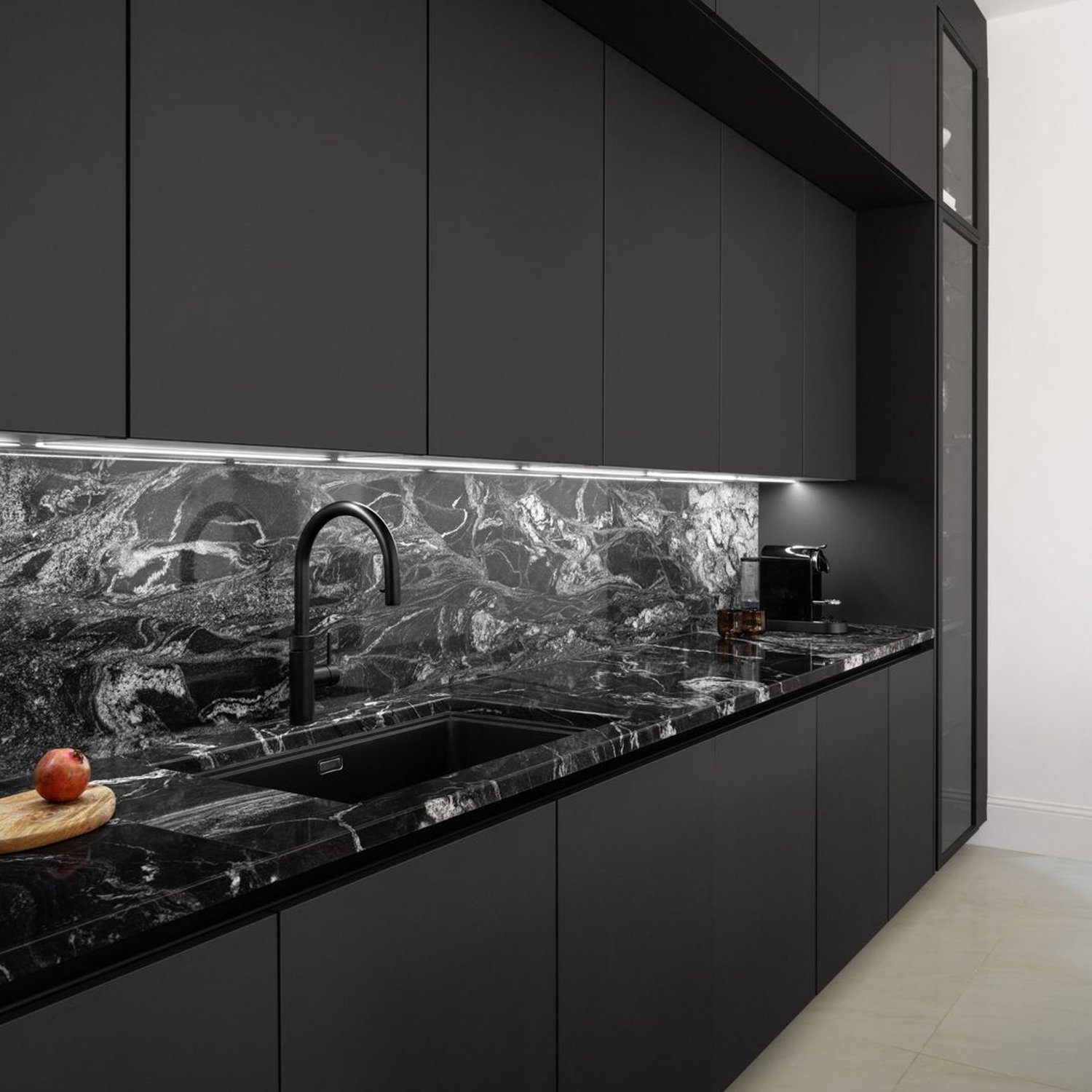 A sophisticated modern kitchen featuring sleek black cabinetry and a dramatic marble backsplash