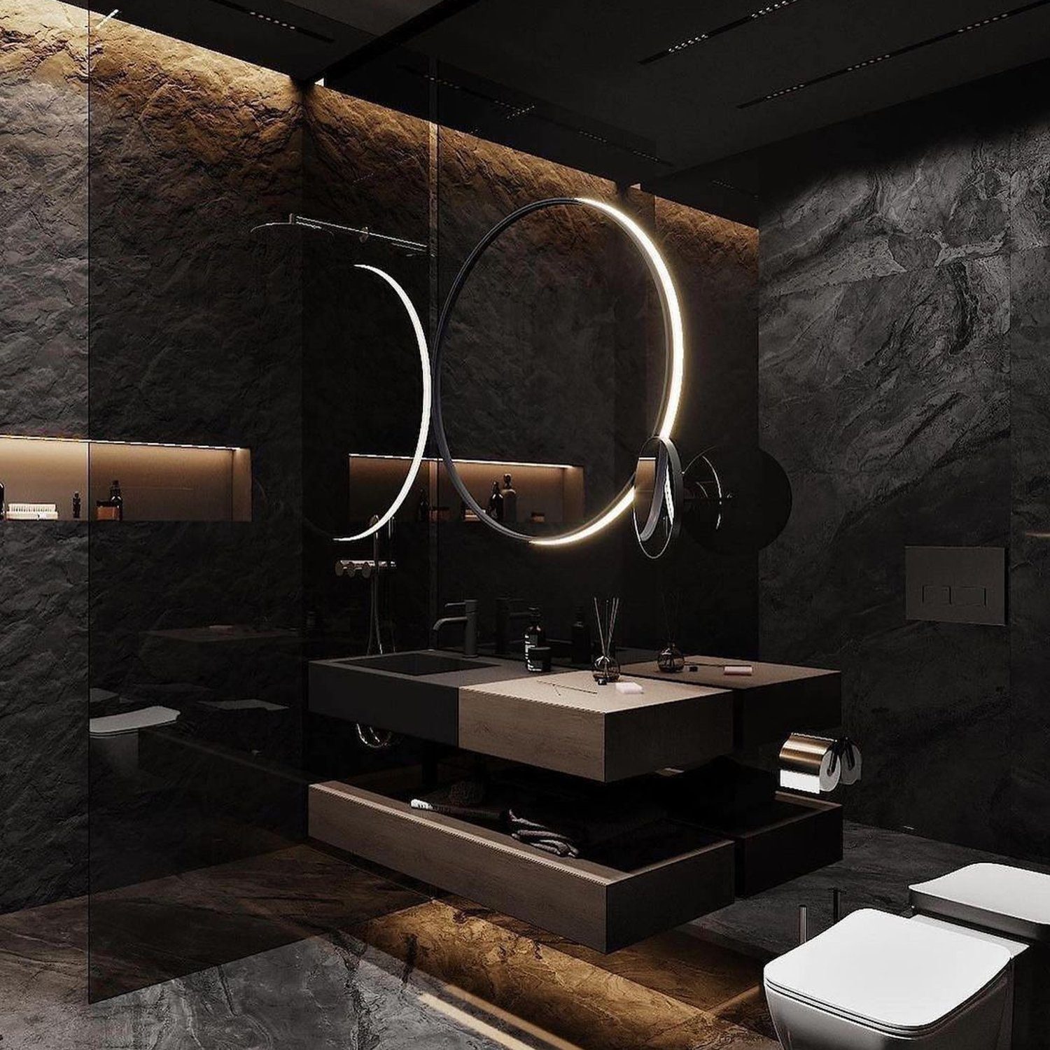 A modern and sleek bathroom design with a circular LED mirror and gray stone accents