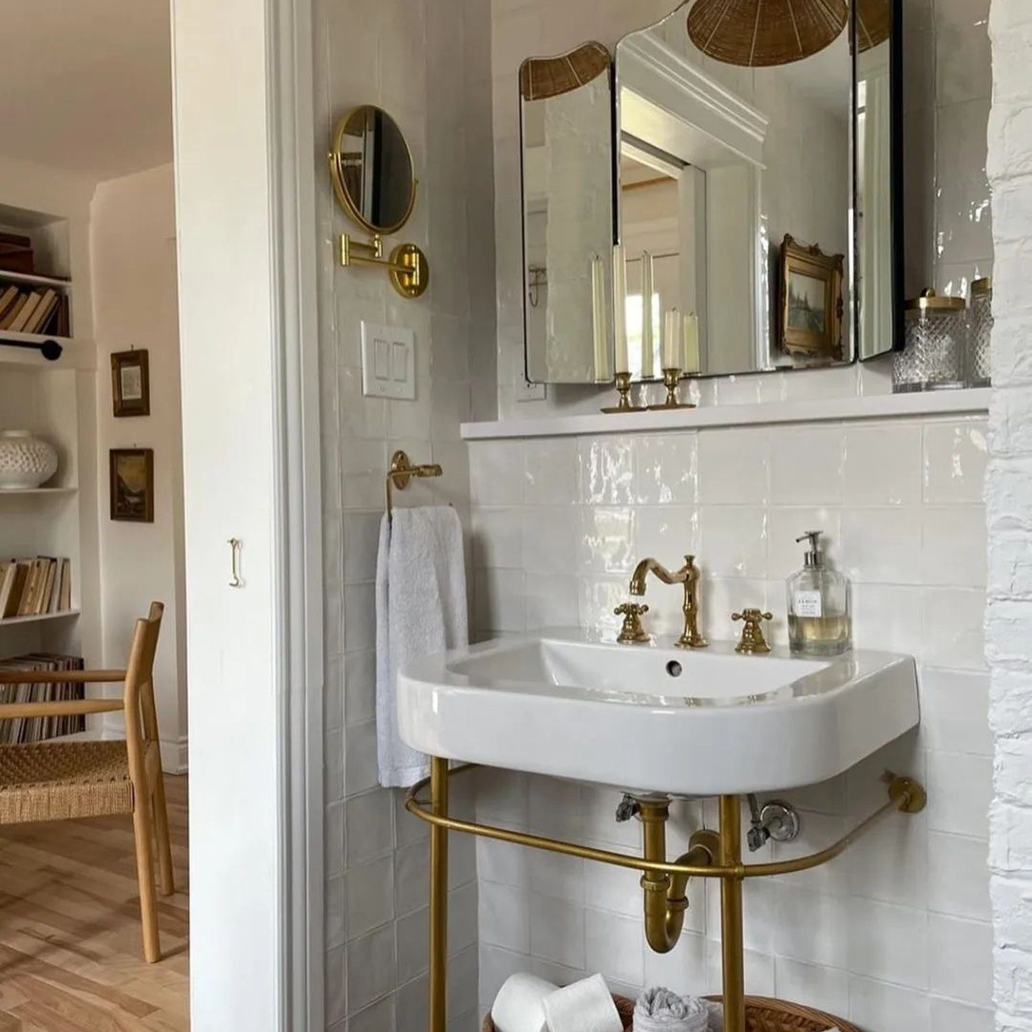 Elegant white bathroom featuring a classic pedestal sink with gold fixtures