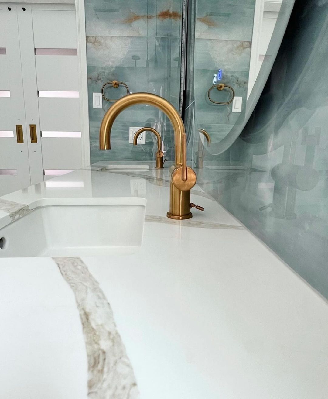 A modern bathroom featuring a sleek golden faucet