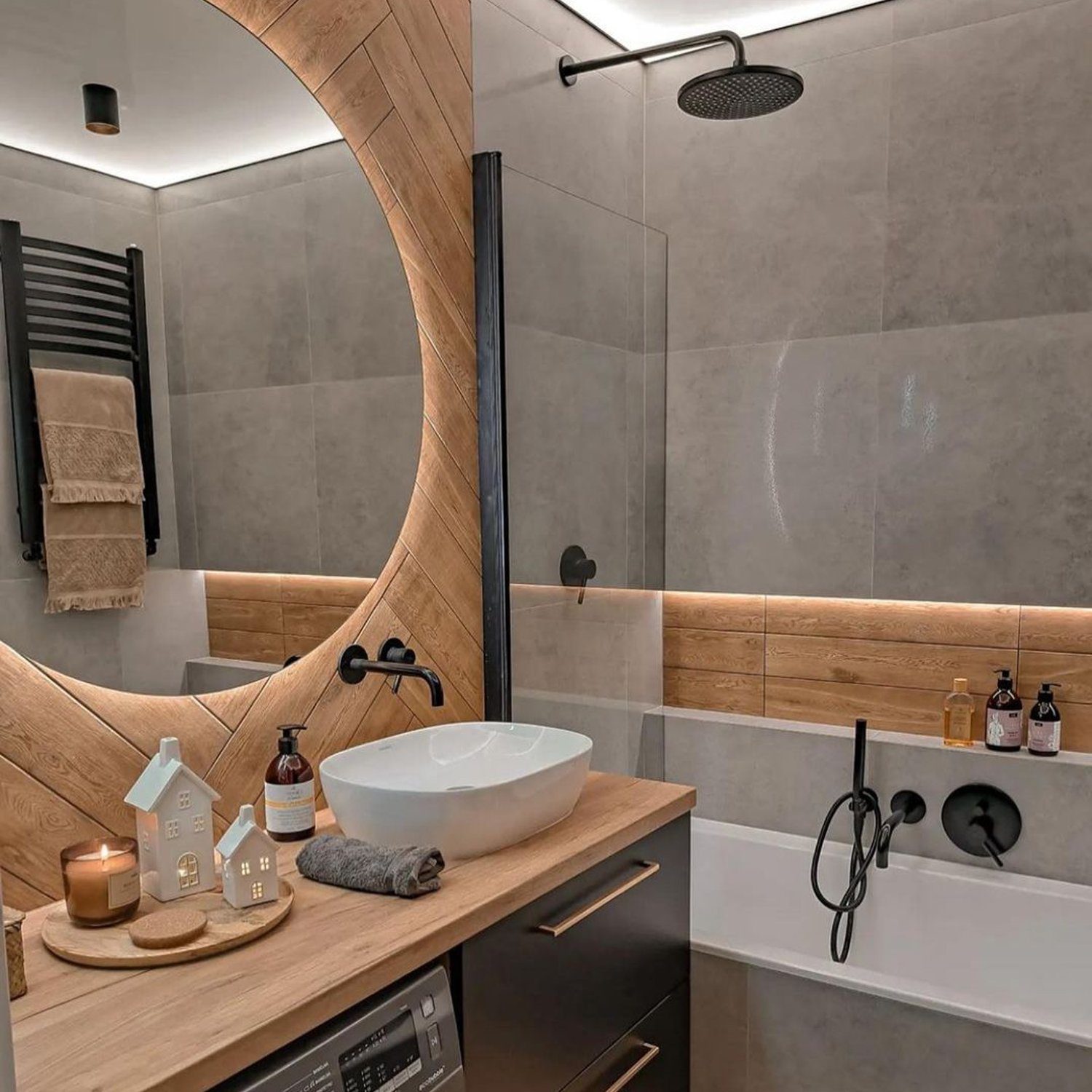 Stylish modern bathroom with a curved wooden mirror frame, grey tiles, and sleek fixtures