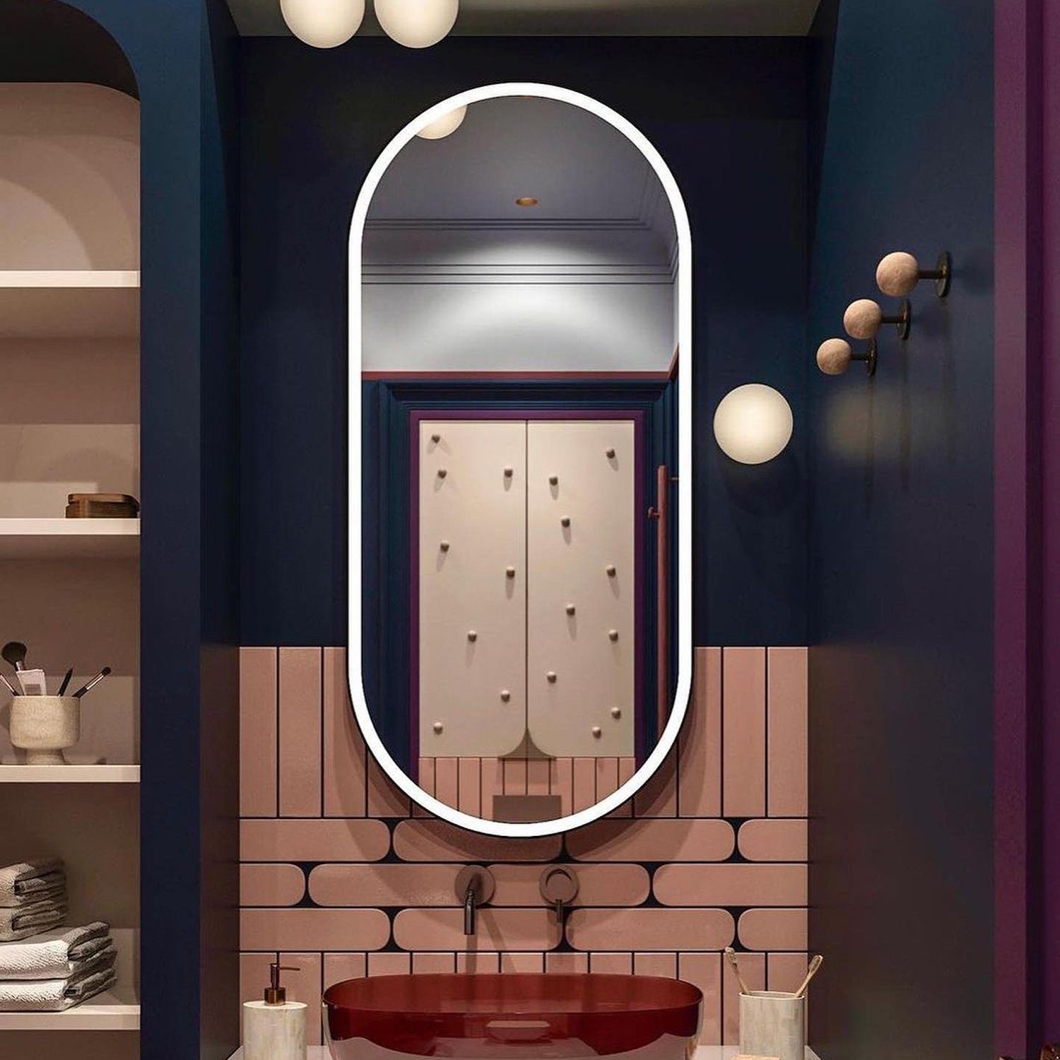 A modern bathroom design featuring deep blue walls, terracotta tiles, and a bold red basin