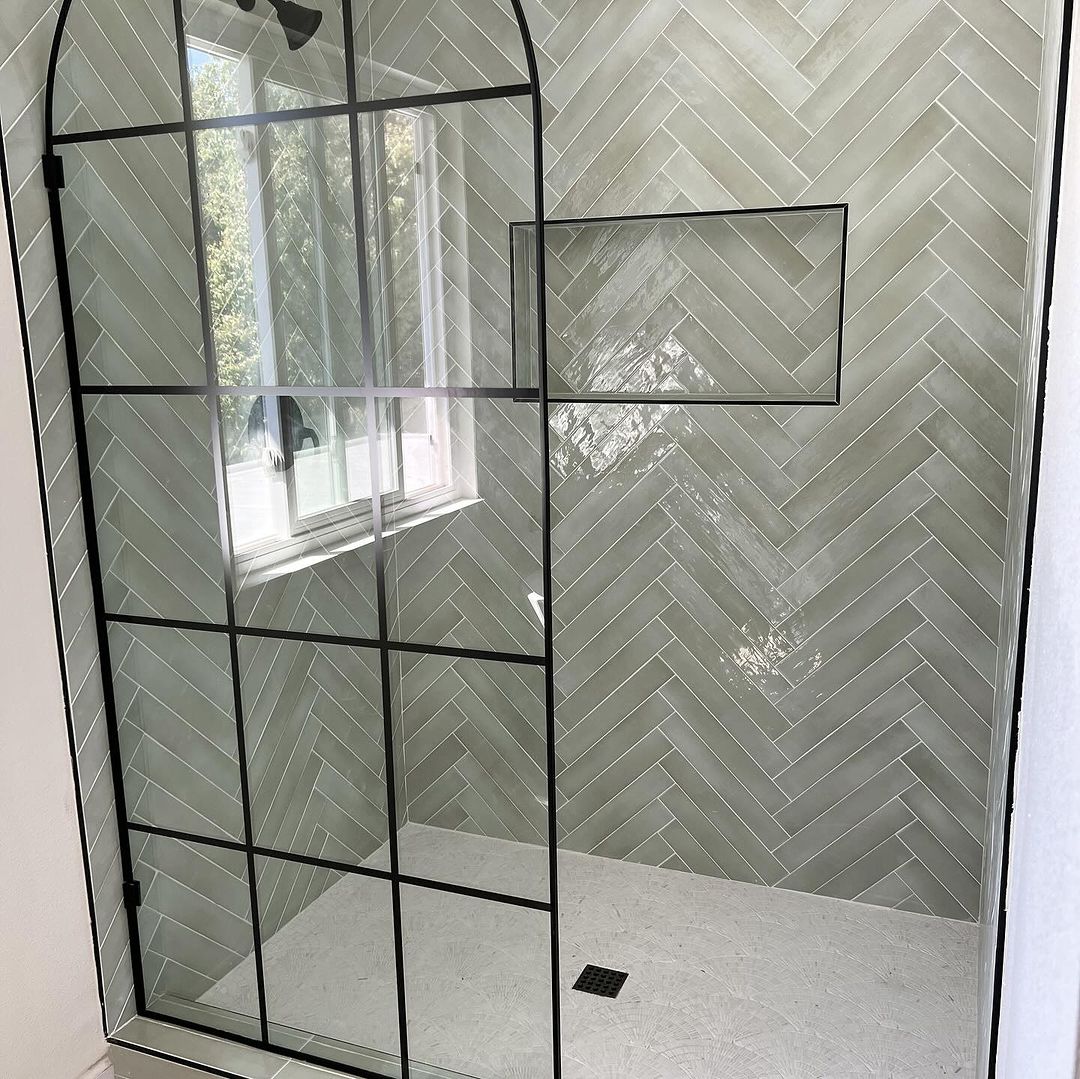 A chic herringbone patterned tile shower enclosure