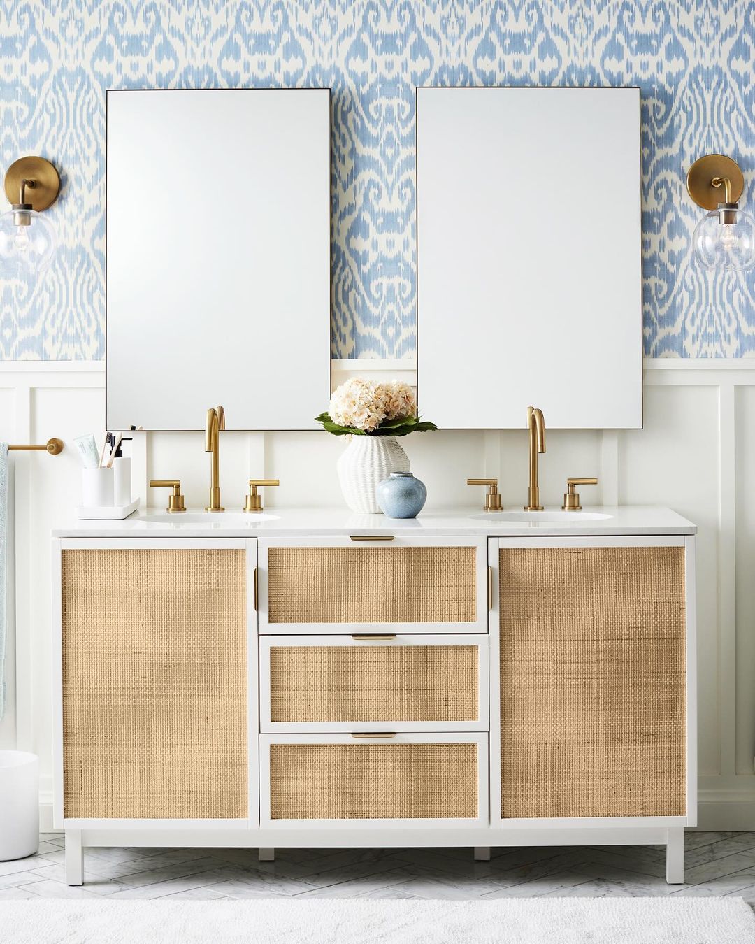 A chic and modern bathroom vanity set against a patterned blue wallpaper