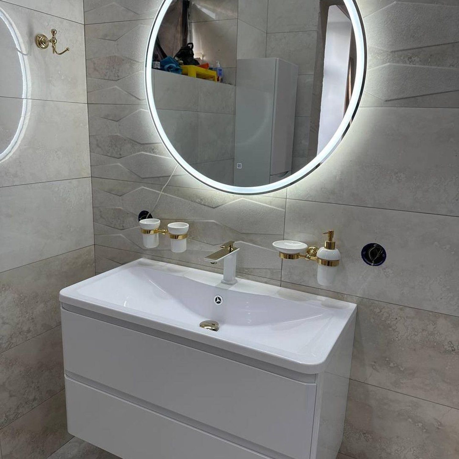 Elegant modern bathroom with illuminated round mirror and floating white vanity