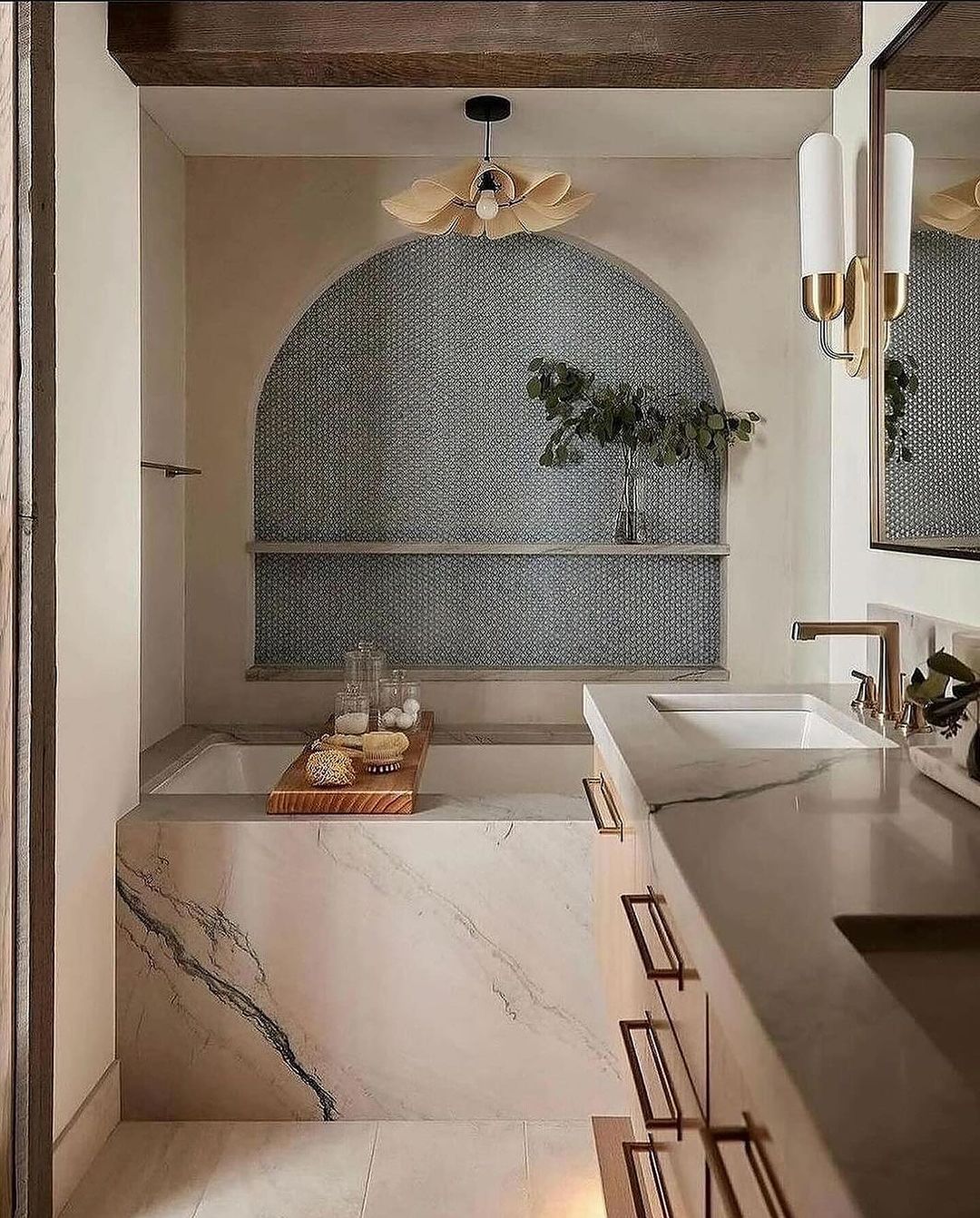 A modern bathroom featuring marble elements and a unique arched nook