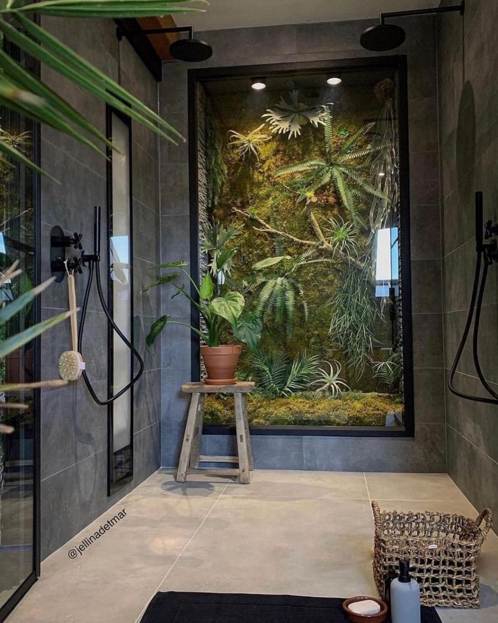 A harmonious blend of nature and design featuring a lush vertical garden visible through a glass wall in a minimalist bathroom with matte black fixtures and a rustic stool.