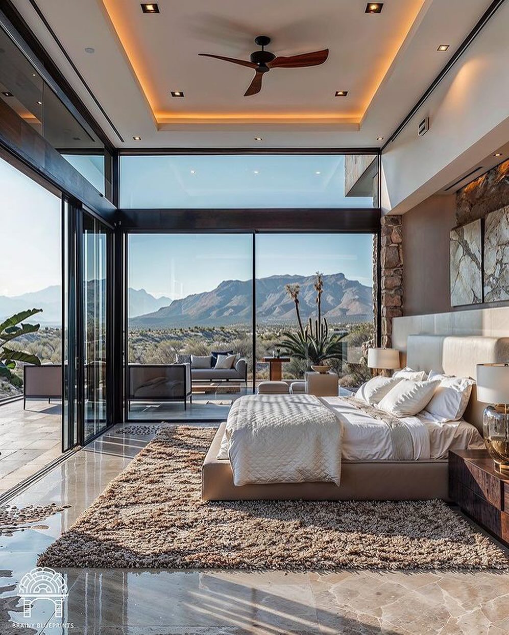 A luxurious bedroom with expansive mountain views through floor-to-ceiling windows