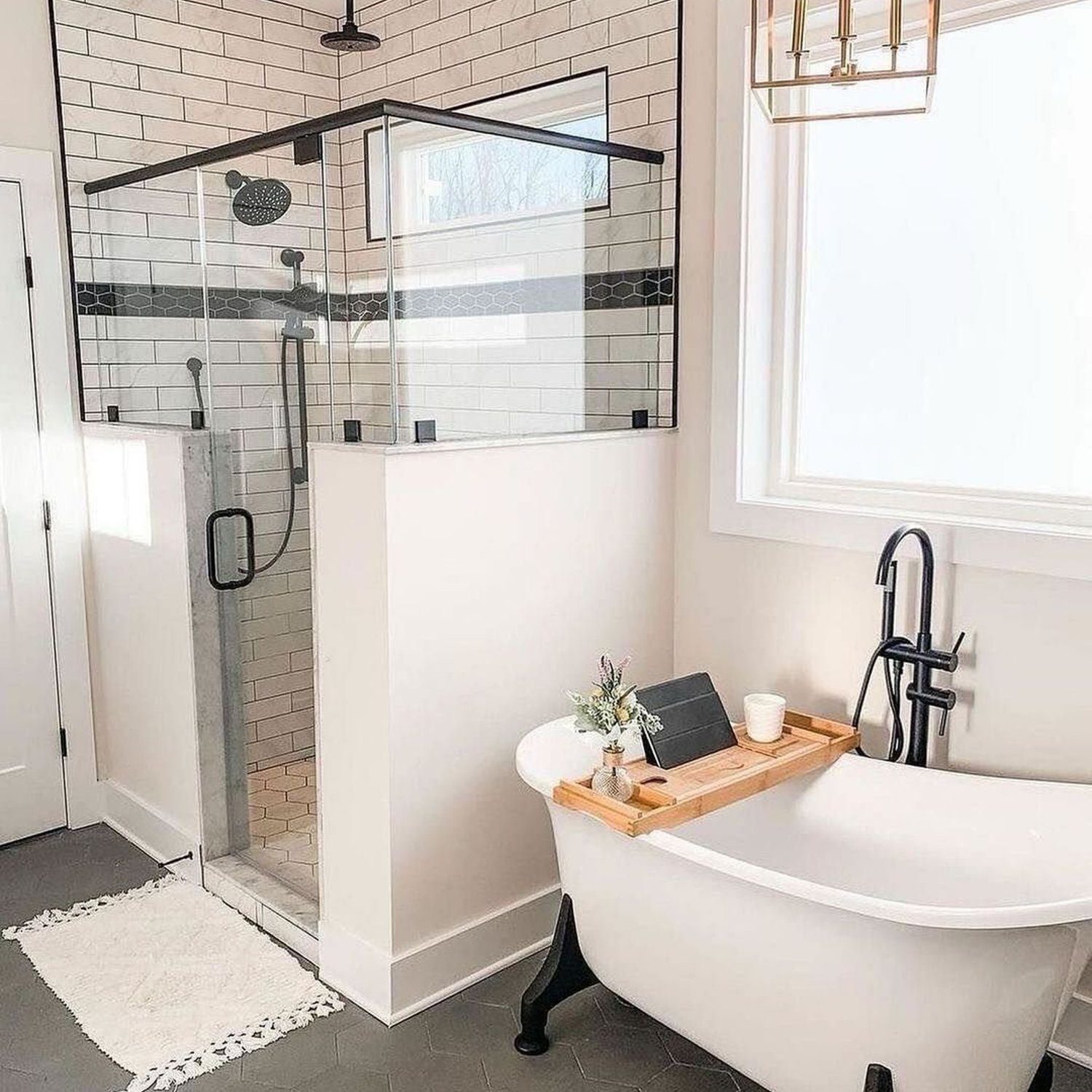 A chic modern bathroom with subway tile walls and contrasting dark grout, featuring a freestanding bathtub with bold black fixtures