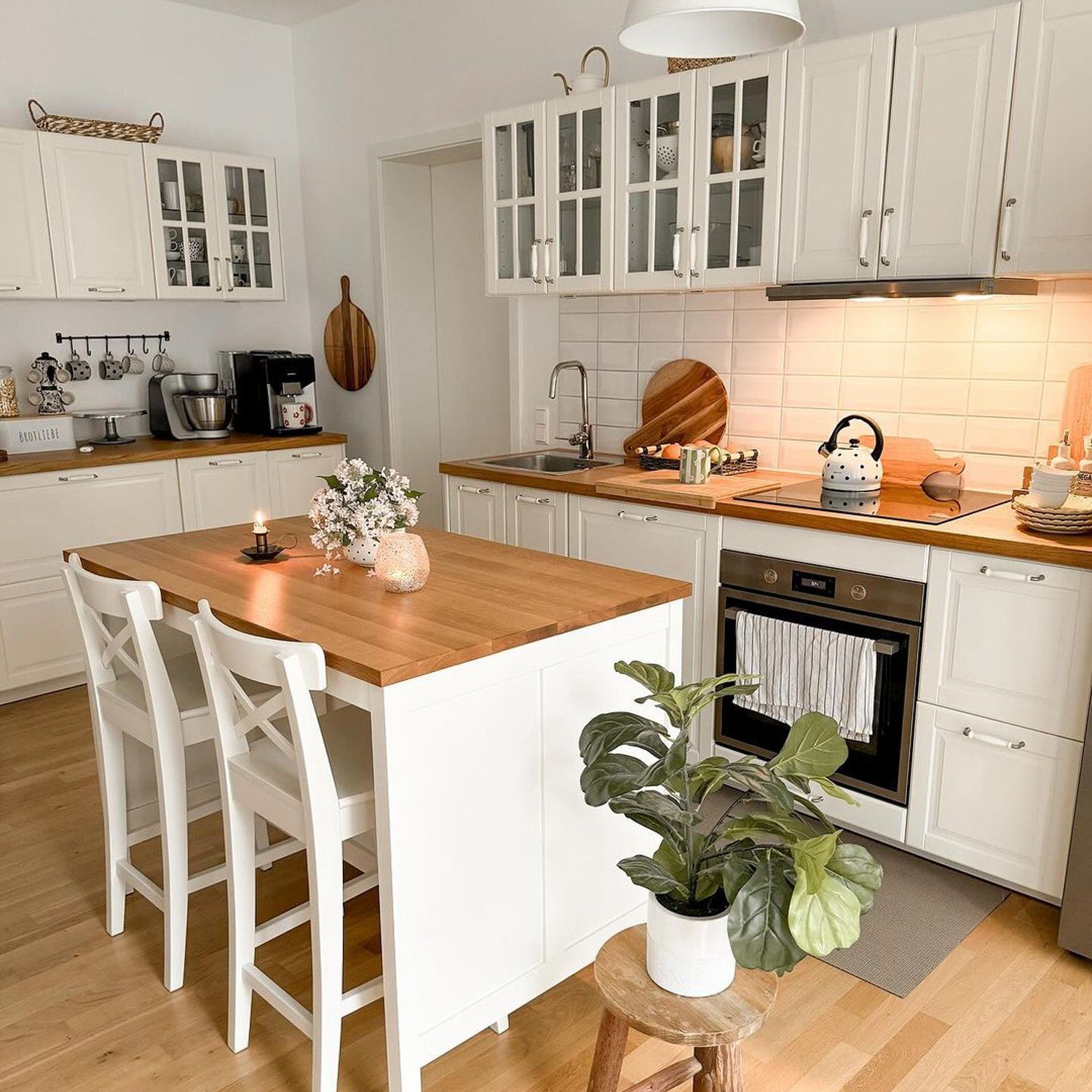 A bright and inviting kitchen featuring white cabinetry, warm wood accents, and modern appliances