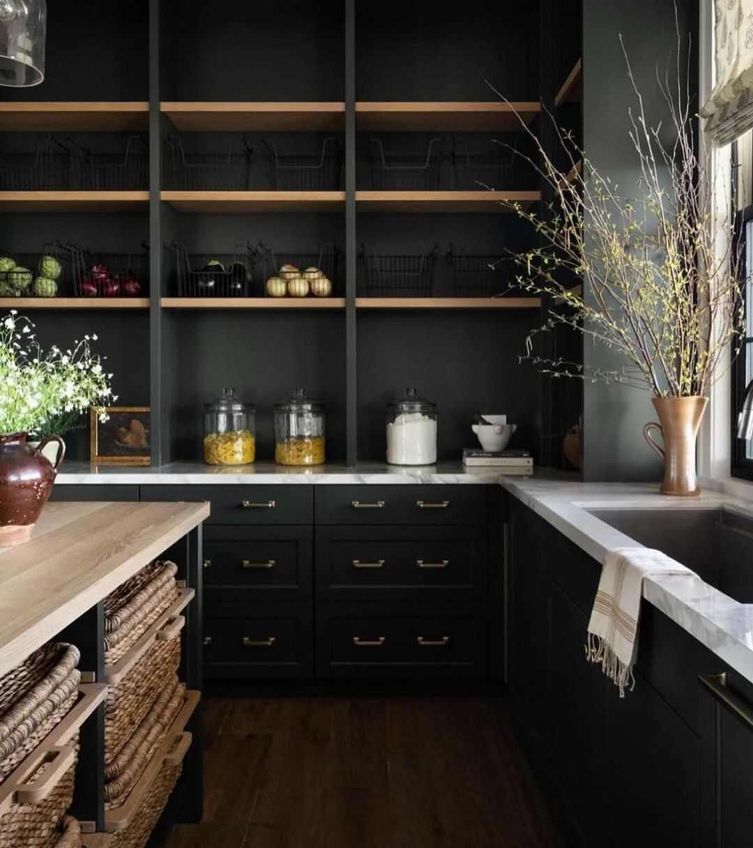 A modern kitchen with dark cabinetry and open shelves