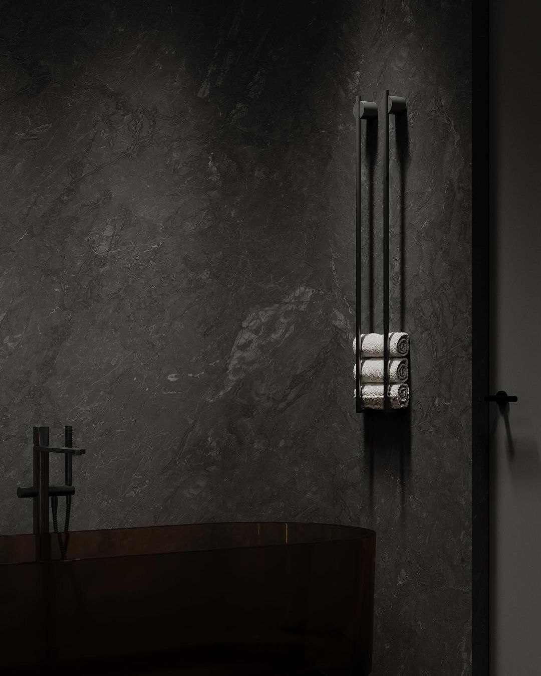 A modern and sleek bathroom featuring dark marble walls and a matte black freestanding bathtub