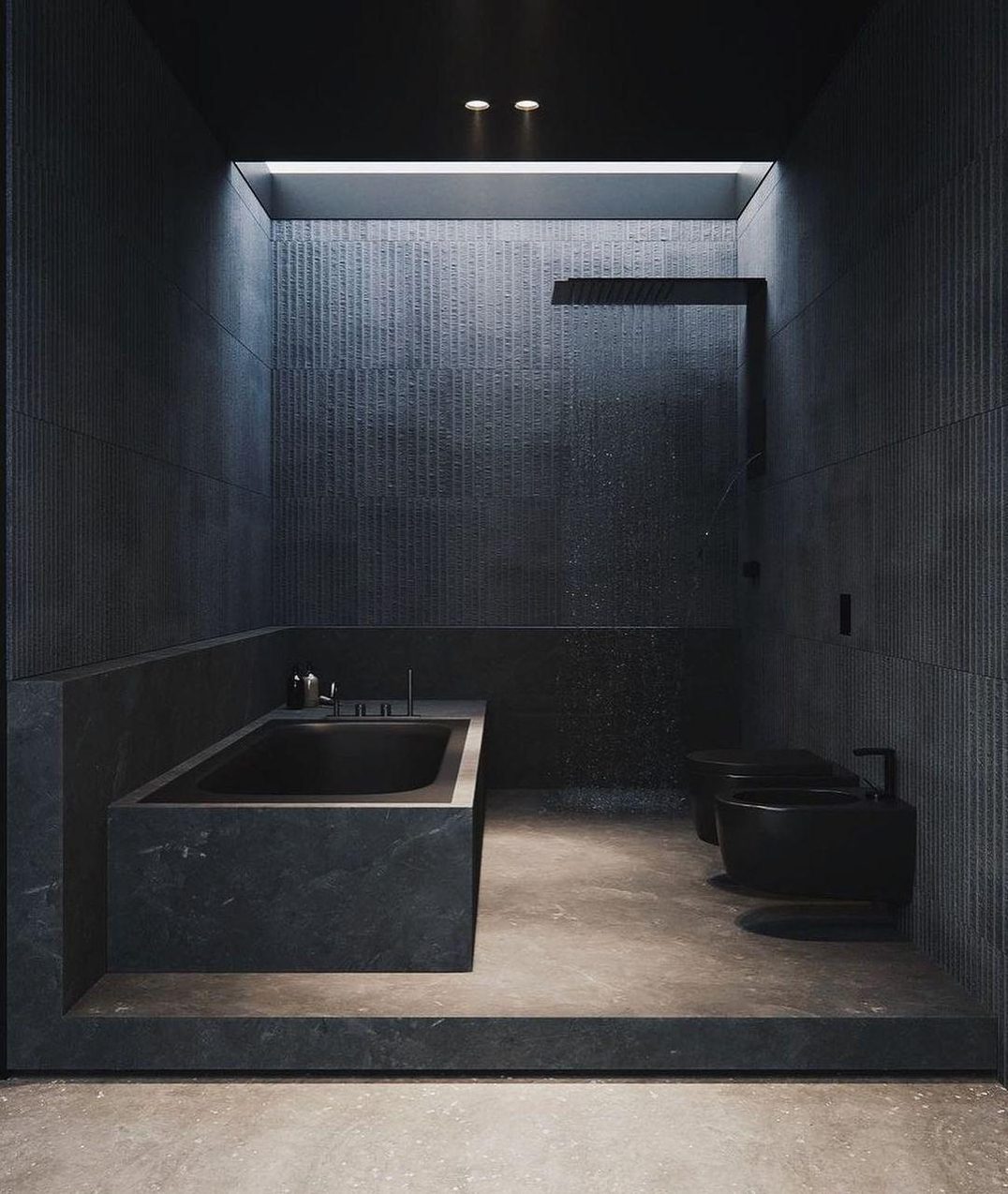 A contemporary bathroom featuring dark tiles, a built-in bathtub, and a minimalist toilet.